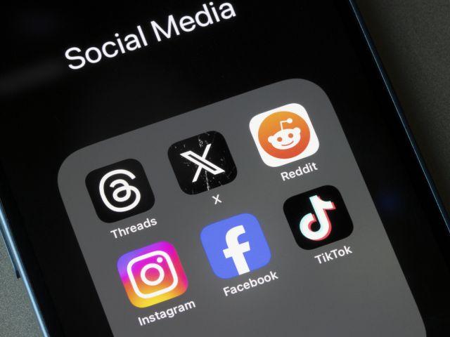 A mobile phone shows the app logos of several social media companies