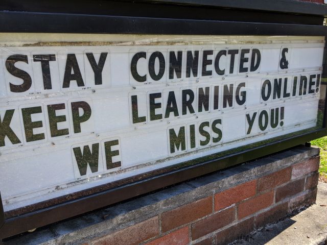 School sign suggests that students must stay away from campus
